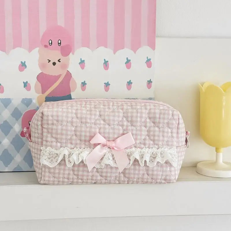 Pink checkered pencil case with a bow on a white surface with a colorful background