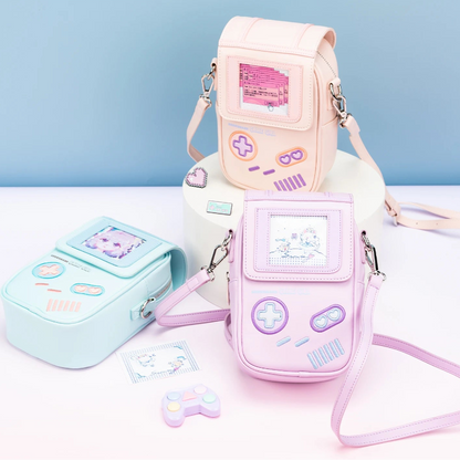 Pink and blue handheld gaming console-shaped bags with a strap on a light blue background.