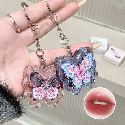 women holding kawaii butterfly lipgloss keychains in pink and blue 