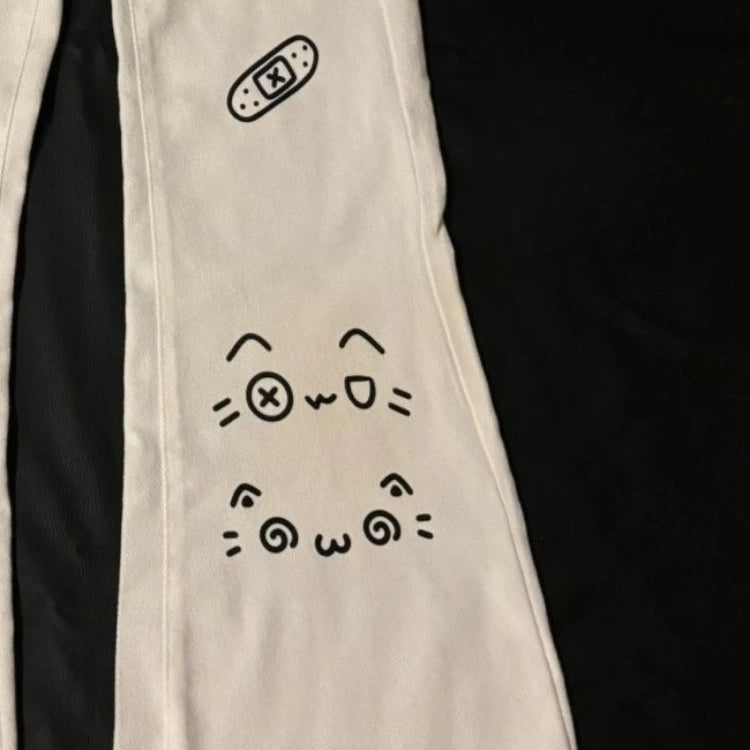 Beige pants with black cat face design on a black background