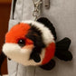 Plush fish-shaped keychain attached to a gray bag