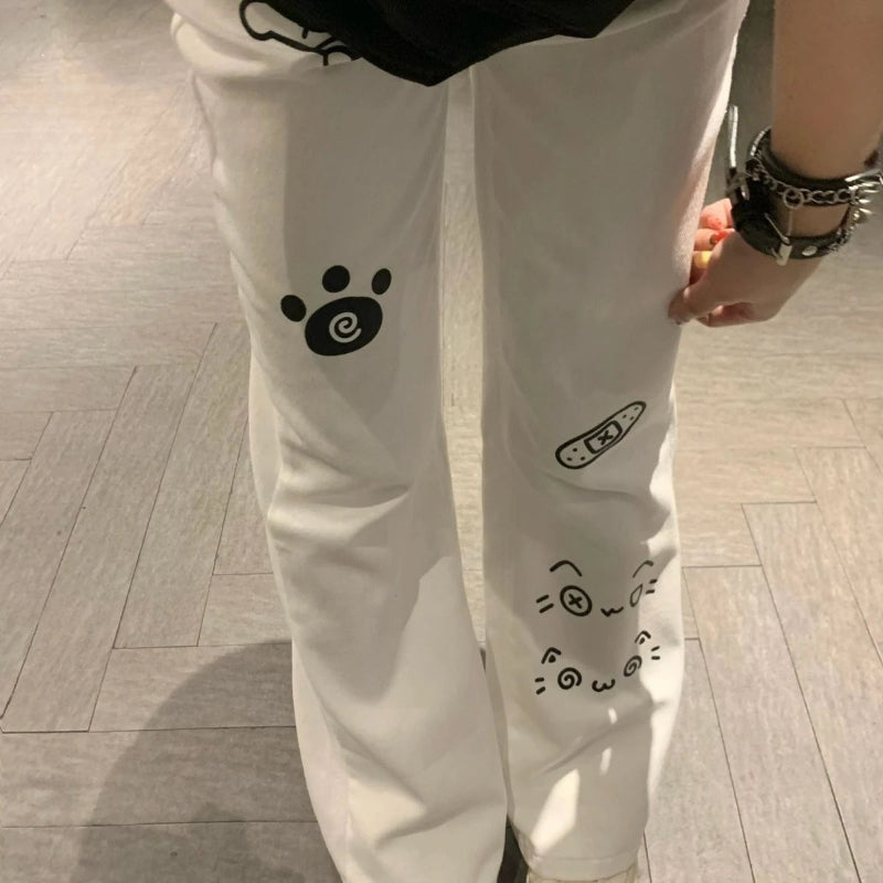 White pants with black paw print design on a wooden floor