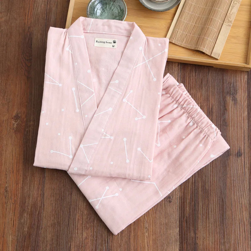 Pink kimono-style garment with white patterns on a wooden surface