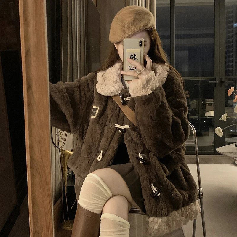 A person takes a mirror selfie wearing a dark brown textured faux-fur jacket with a cream-colored collar, a beige beret, and white thigh-high socks in an indoor setting.