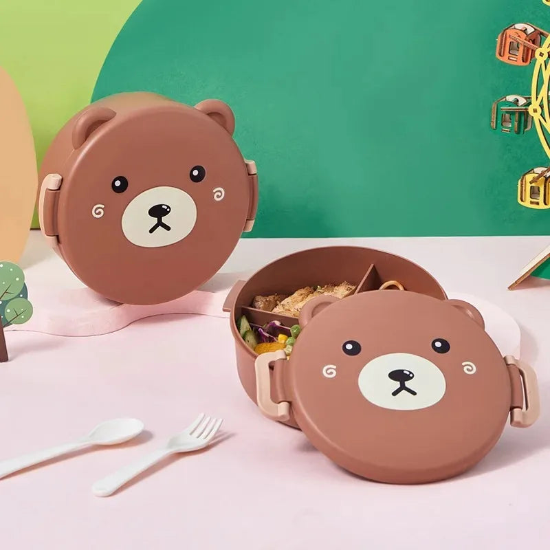Bear-shaped lunch box with food on a pink surface with a green background