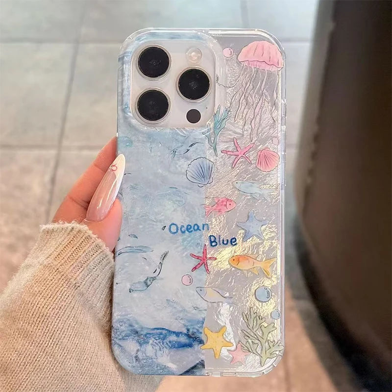 Phone case with ocean-themed design held by a person