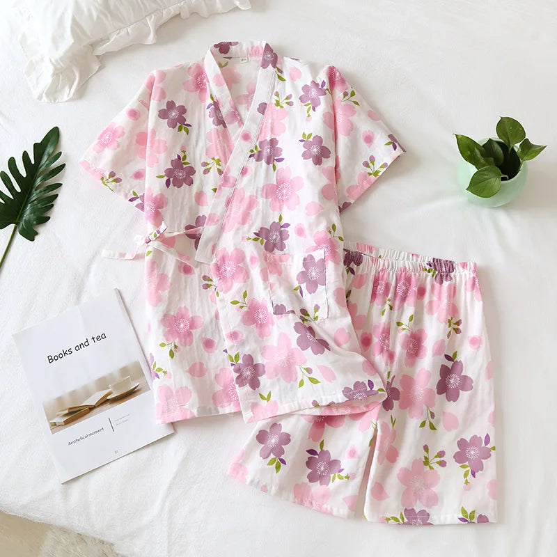 Floral pajama set on a white surface with a plant and book.