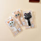 Three kawaii cat-shaped push pins in packaging on a beige background