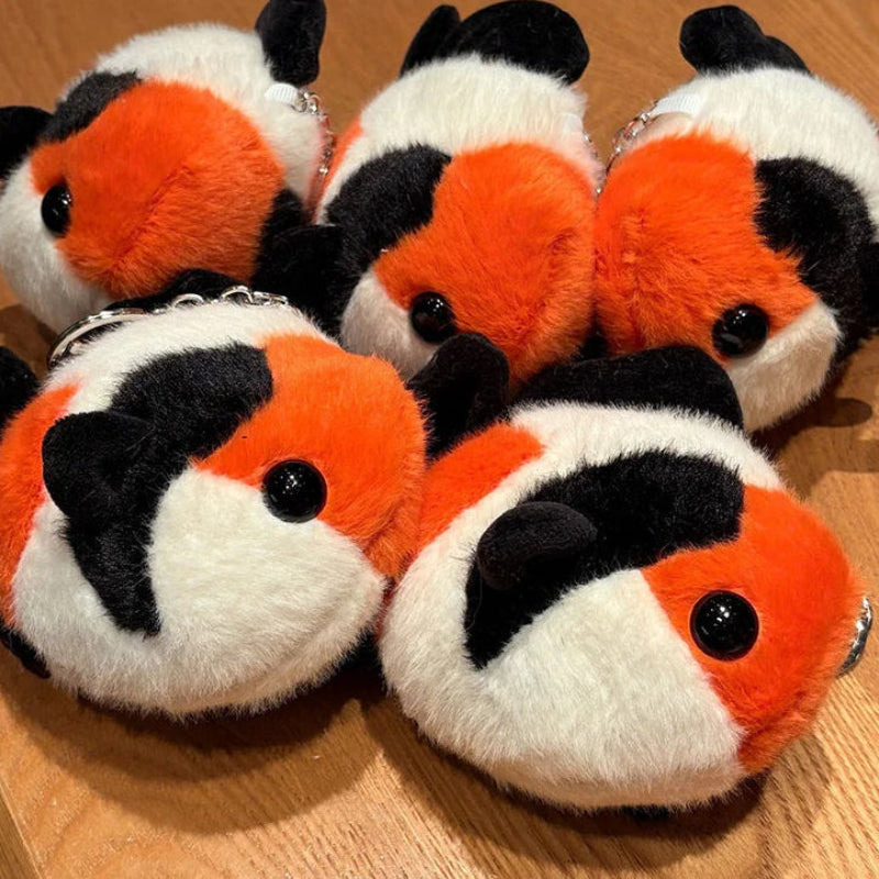 Plush keychains shaped like clownfish on a wooden surface