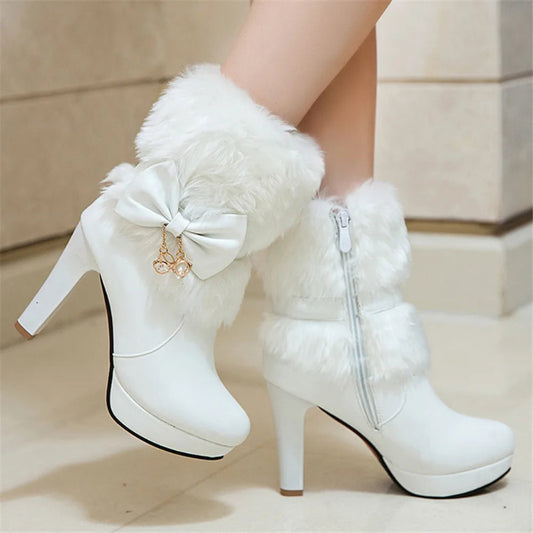 White high-heeled boots with fluffy fur and a bow on a neutral background