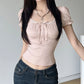 Woman wearing a cute pink top and blue jeans against a plain background