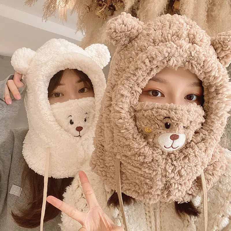 Two people wearing fluffy bear-themed hats with teddy bear faces inside.