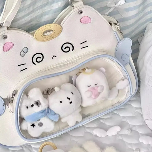 Cute plush toys inside a cat-shaped bag with a face design on a soft background.