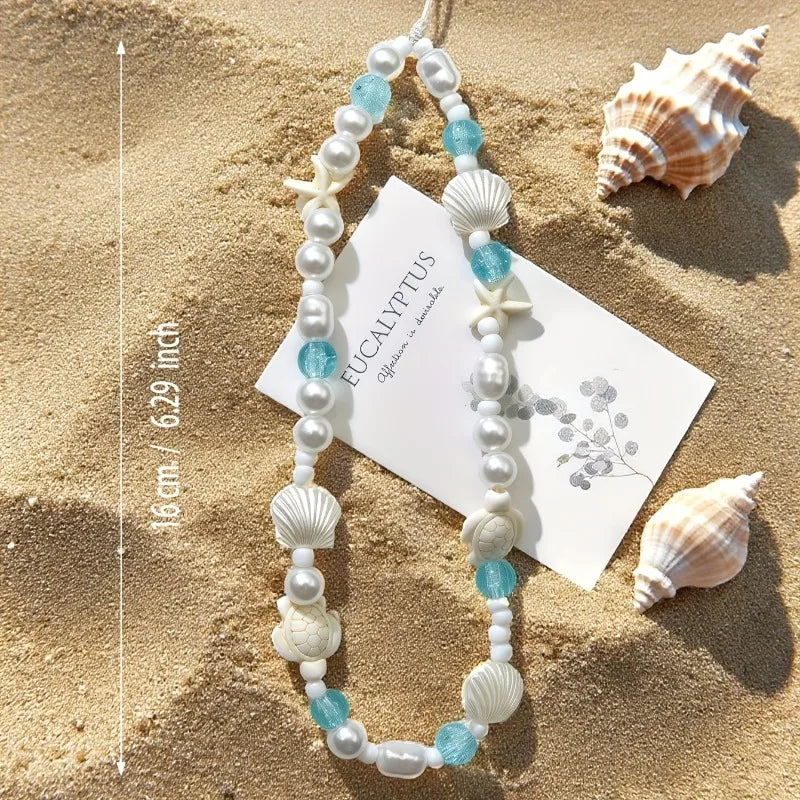 Mermaid treasure phone charm bracelet displayed on sandy beach with measurements.