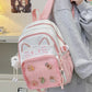 Pink neko backpack displayed by person holding them.