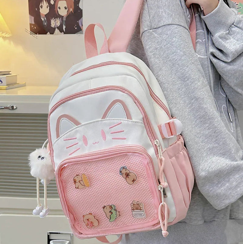Pink neko backpack displayed by person holding them.