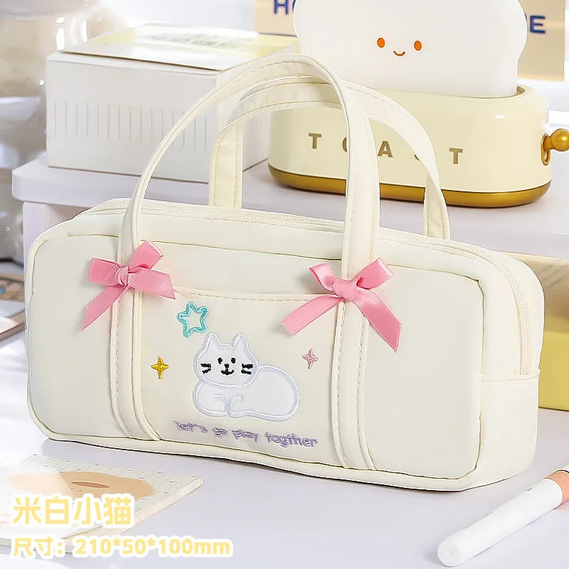 White pencil case with cat design and pink bows on a light background