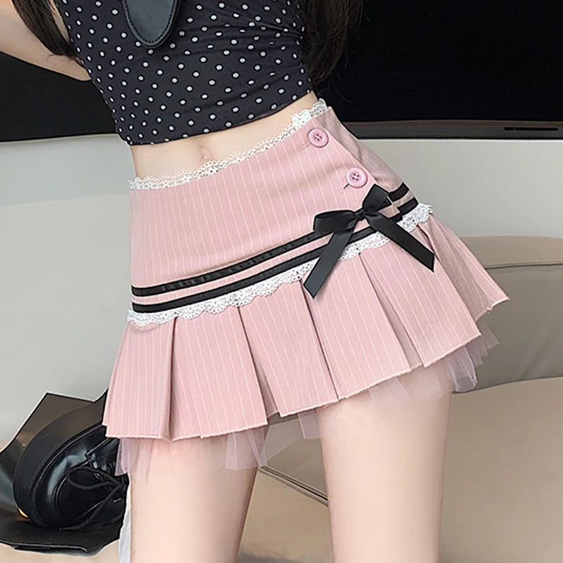 Person wearing a pink pleated skirt with a black ribbon on a neutral background