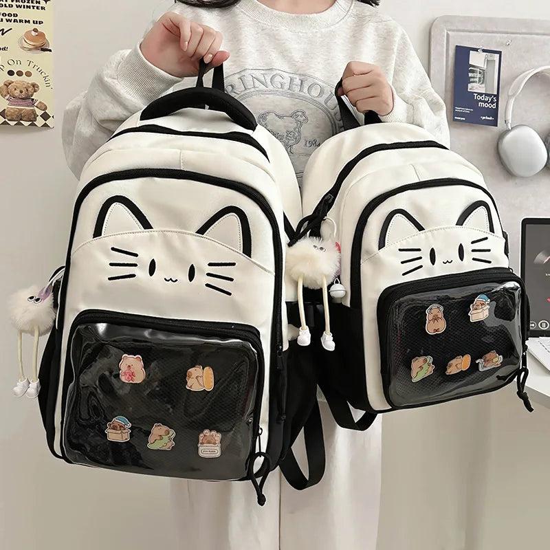 Black neko backpack displayed by person holding them.