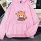 Pink hoodie with a red panda design on a surface with newspapers underneath