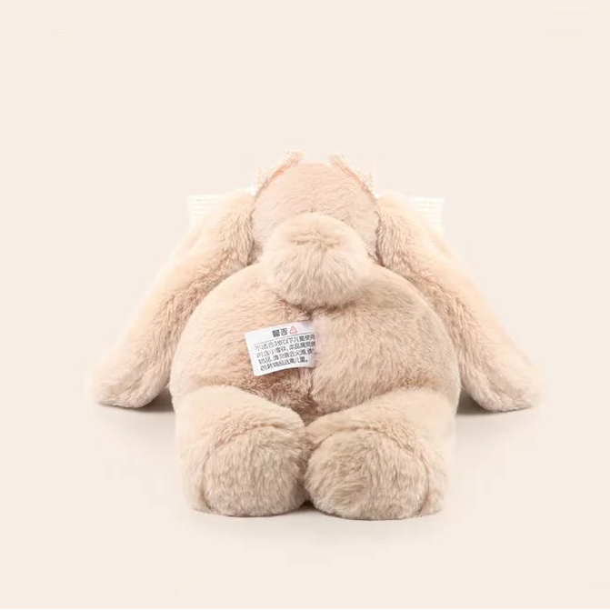 Plush kawaii bunny toy with a label on a beige background.