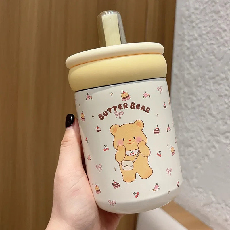 Children's tumbler with bear design and 'Butter Bear' branding held by a hand.