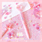 Pink glittery surface with decorative pens and accessories on a pink background