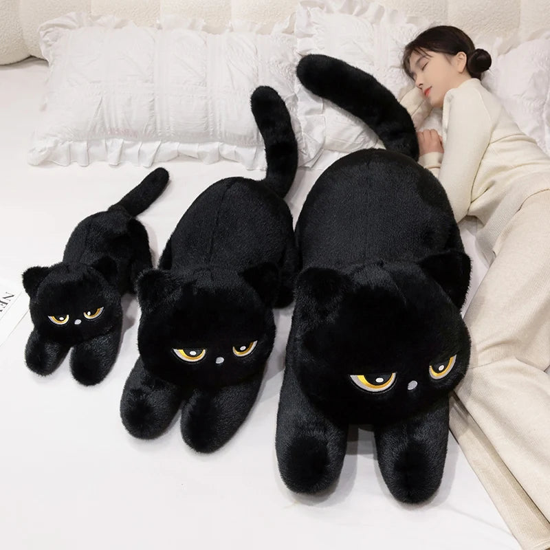 Woman sleeping with three black Kawaii sleepy cat body pillow plushies on a bed 