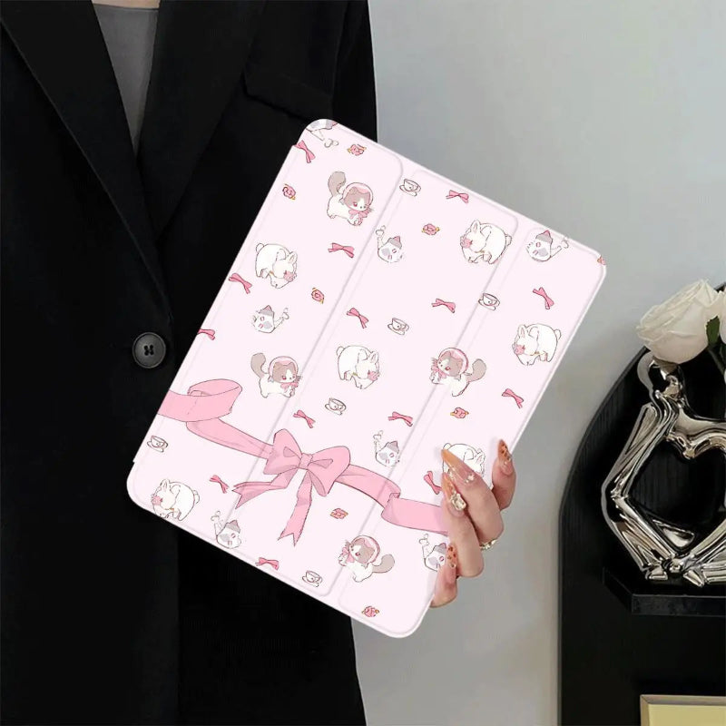 Person holding a pink tablet case with cartoon designs and ribbons.