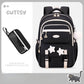Black backpack with star designs and a small black pouch on a light gray background.