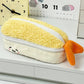 Kawaii yellow tempura shrimp plush pencil case with a cute face on a white desk