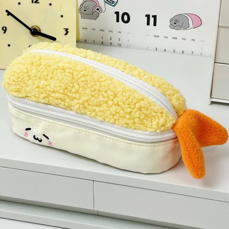Kawaii yellow tempura shrimp plush pencil case with a cute face on a white desk