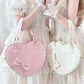 Two heart-shaped bags, one pink and one white, held by a people in white dresses.