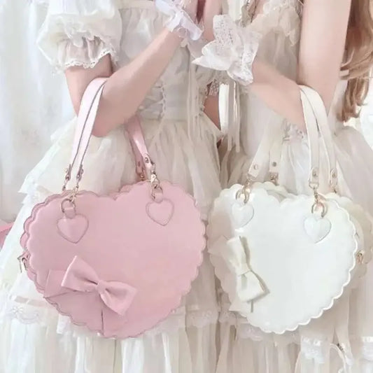 Two heart-shaped bags, one pink and one white, held by a people in white dresses.