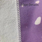 Close-up of textured fabric edge with a purple background
