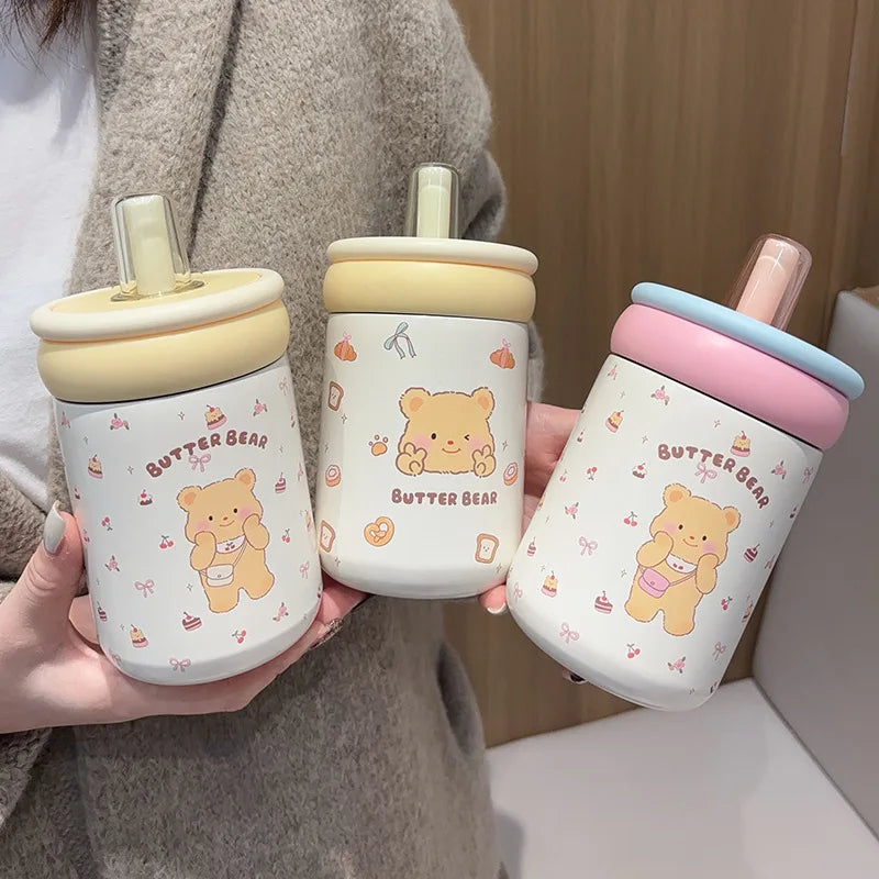 Three kawaii cups with bear designs and colorful lids held by a person.