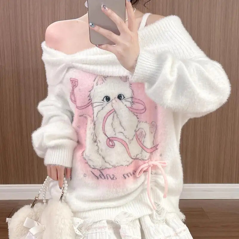 Person wearing a white sweater with a cat design, taking a mirror selfie.