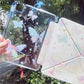 Clear ipad case with butterfly designs held outdoors