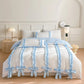 White bed with light blue ruffled trim in a bedroom setting