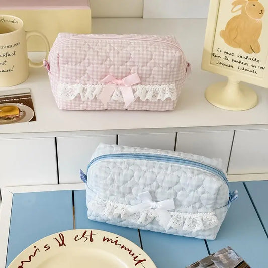 Two decorative pencil cases with lace details on a surface.