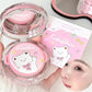 Pink cosmetic compact with kawaii bear design held by a hand, with a blurred face in the foreground.