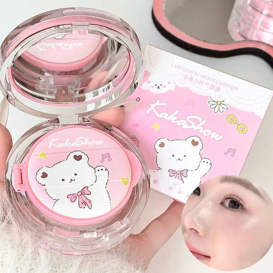 Pink cosmetic compact with kawaii bear design held by a hand, with a blurred face in the foreground.
