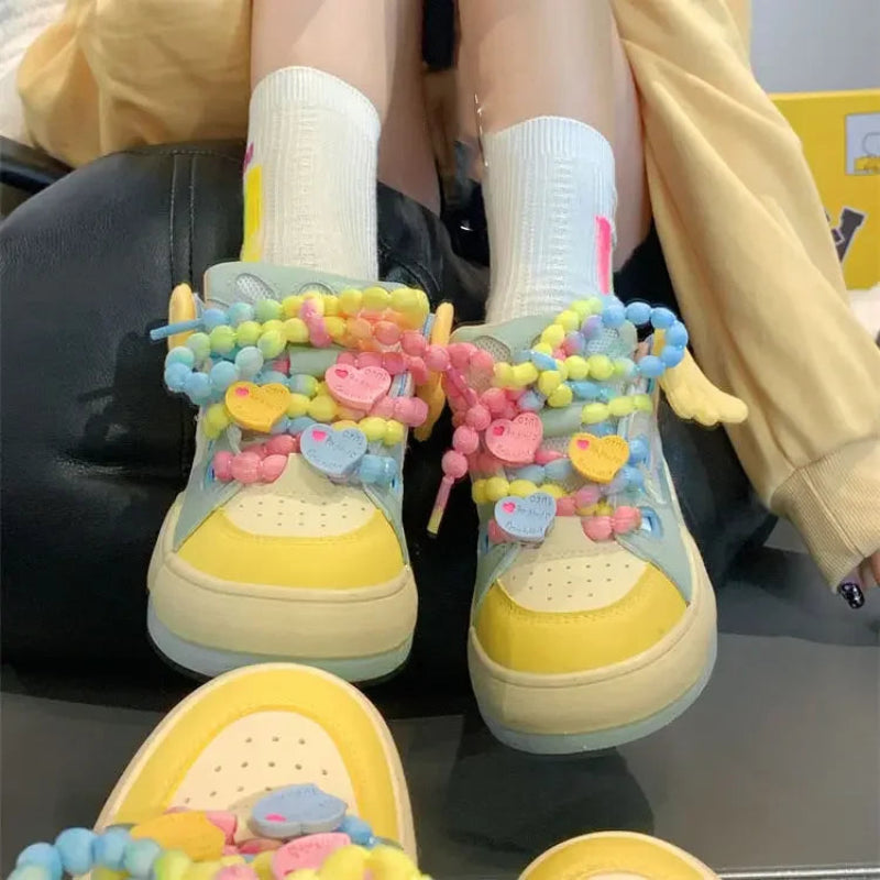 Angel on a rainbow platform sneakers, being displayed in front of a yellow hoodie and a mirror