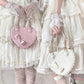 Two people in white dresses holding pink and white heart-shaped bags.