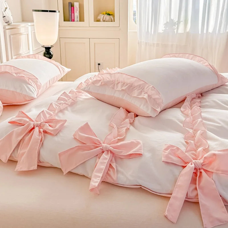 Pink bedspread with ruffles and bows on a bed in a bright room.
