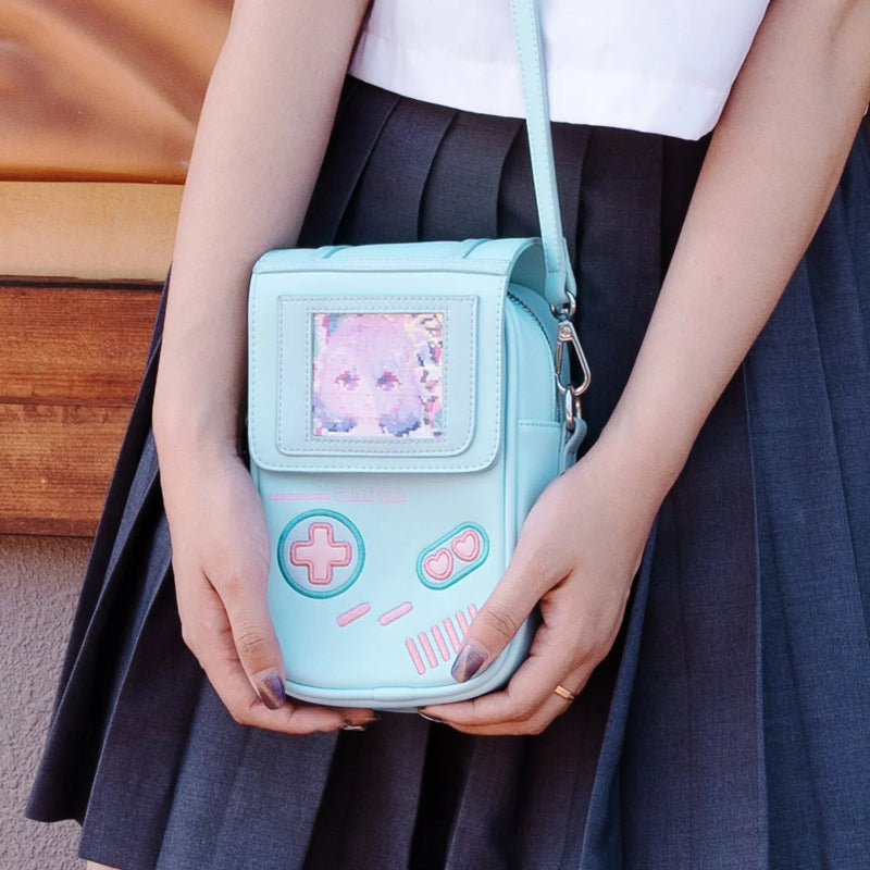 Light blue game console-shaped handbag held by a person wearing a dark skirt.