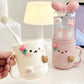 Kawaii toothbrush container with animal designs on a light surface.