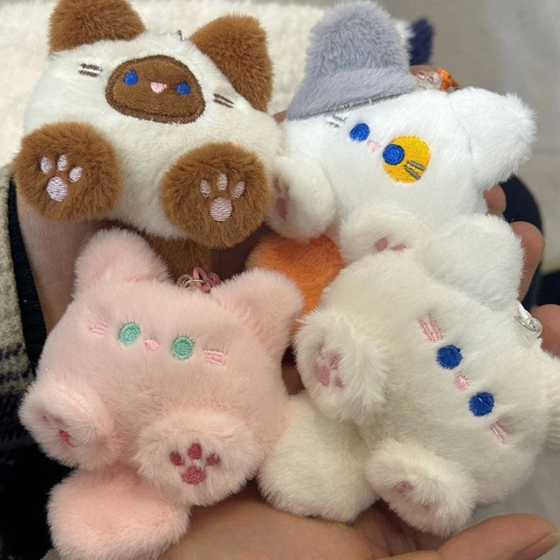 Four plush toys of different colors held together, with a neutral background.