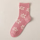 Pink sock with white floral patterns on a beige background