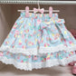 Blue skirt with colorful pattern and lace trim hanging on a rack.